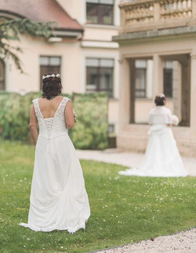 Premier regard ému entre deux mariées, l'une d'elles découvrant sa future épouse en robe de mariée lors du 'First Look'.