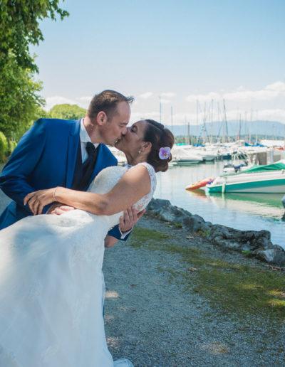 Le marié embrassant la mariée devant le port de Sciez au Lac Léman