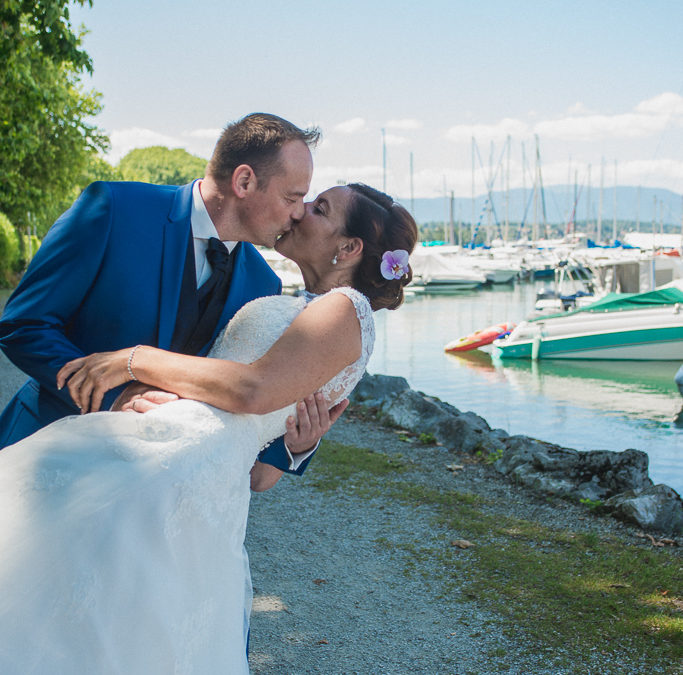 Le marié embrassant la mariée devant le port de Sciez au Lac Léman.