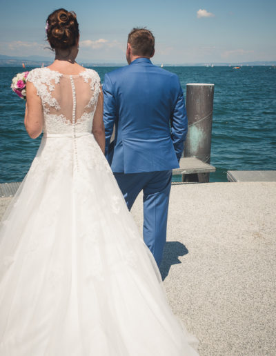 Premier regard ému du marié découvrant sa future épouse en robe de mariée devant le lac Léman à Sciez