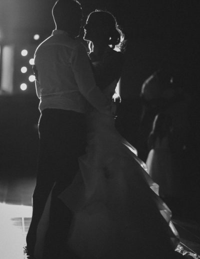 Première danse romantique des mariés, capturée en contre-jour sous les lumières de leur mariage.