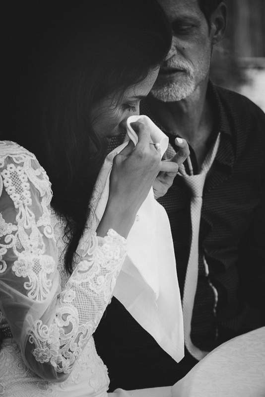 Une mariée émue essuyant délicatement ses larmes, capturant ainsi l'instant le plus sincère et émouvant de son mariage. Une photographie empreinte d'authenticité et d'émotion, signée Philippe Rousseau, votre photographe de mariage à Annecy.