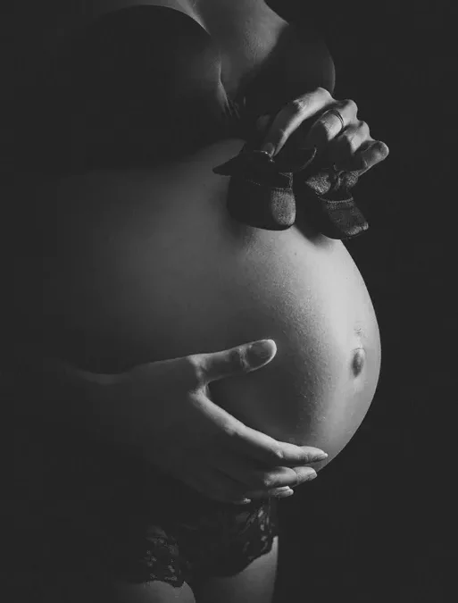 Chaussons de bébé lors d'une séance photo de grossesse à Annemasse - Moment tendre et émouvant pour garder un souvenir de votre grossesse